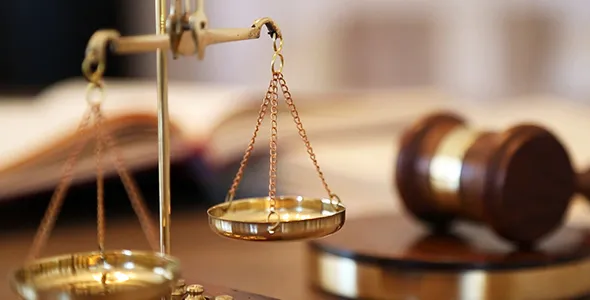 Golden scales of justice beside a wooden judge’s gavel